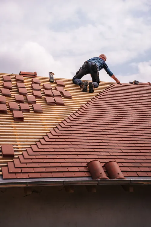 A roofing professional working on a shingle roof